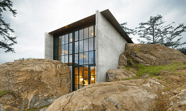 A building made from architectural precast concrete rises up from a hillside.