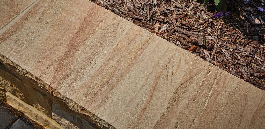 Harvest Gold Sandstone caps are shown atop a small retaining wall.