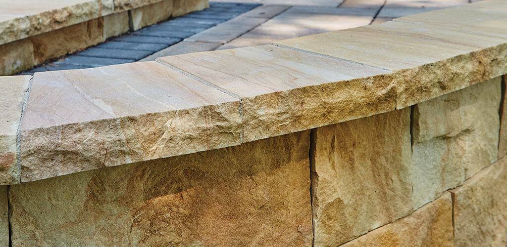 Harvest Gold Sandstone caps are shown atop a small retaining wall.