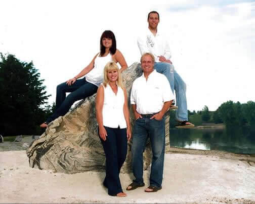 The Kafka family poses for a picture around a large boulder.
