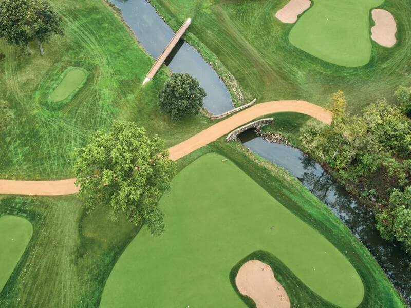 An aerial view of a golf course with a beautiful pathway meandering through it.