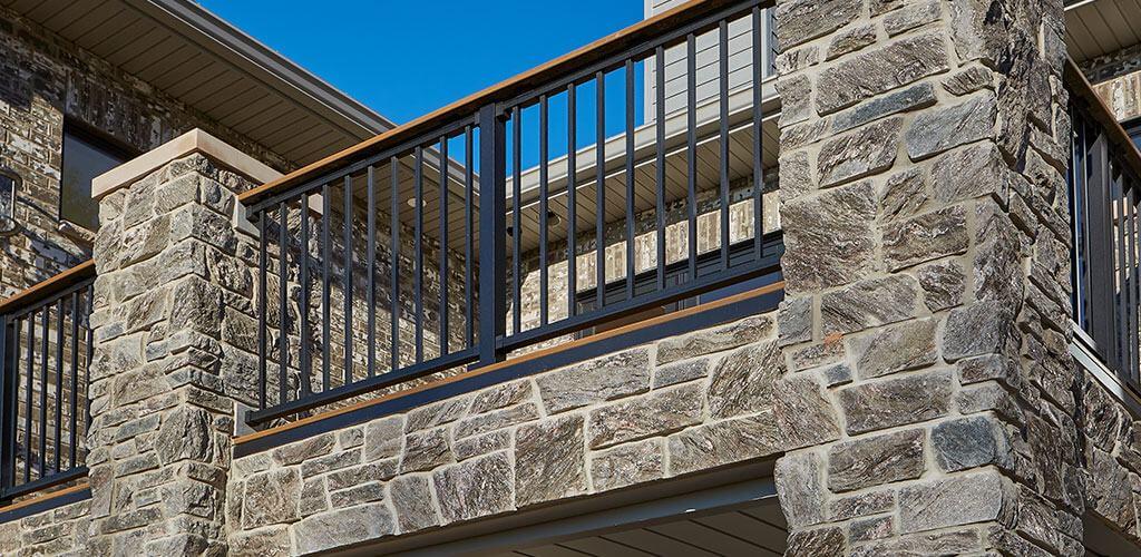 A balcony is shown featuring beautiful stone veneer columns and supports.
