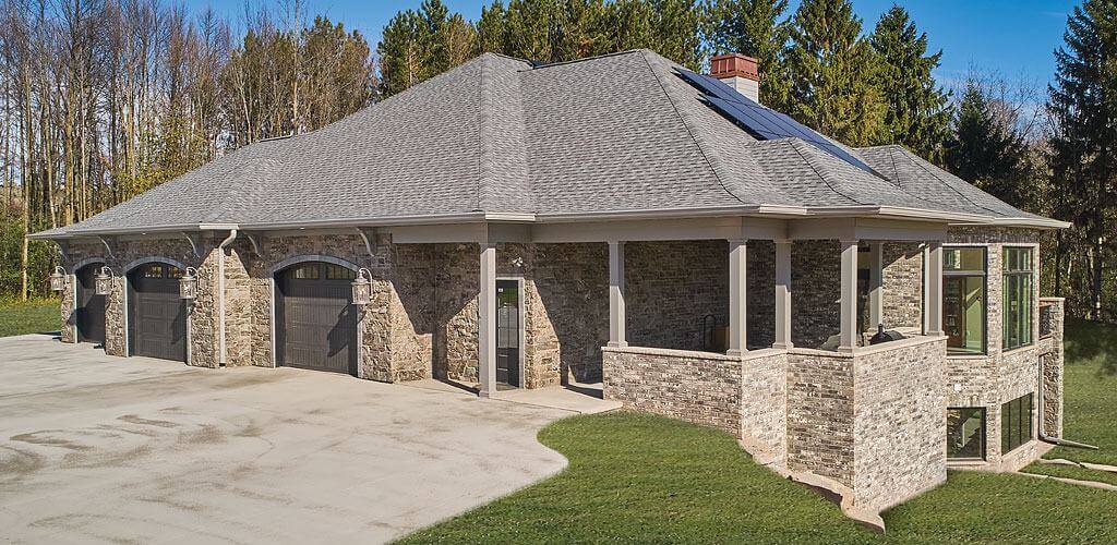 A upscale house is featured with an exterior made entirely of natural stone.