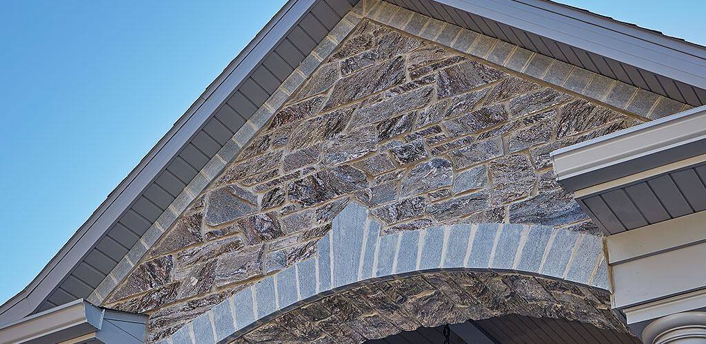 A photo of Galaxy Glitter Dimensional Thin Stone Veneer used above the grand entrance of an impressive estate.
