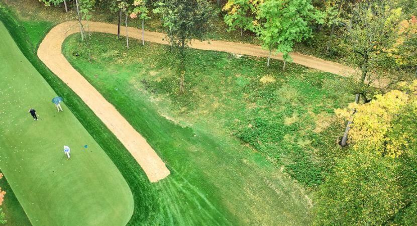 An aerial shot of a golf course is shown with beautiful wax polymer pathway from Kafka Granite.